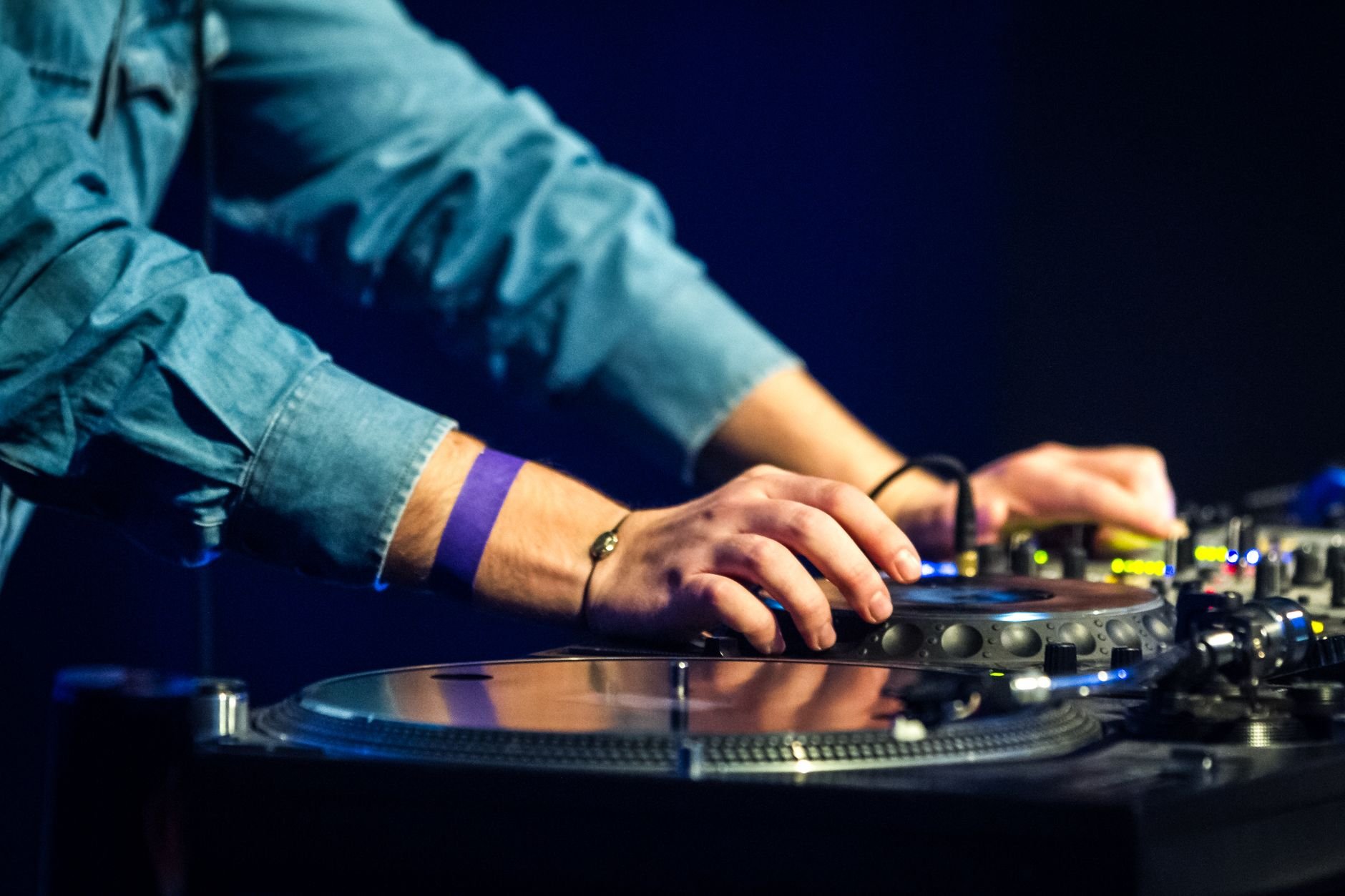 Close-up of DJ hands on turntable at a Berlin club event